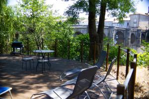 a patio with chairs and a table and a fence at Pont Vieux Gites in Confolens