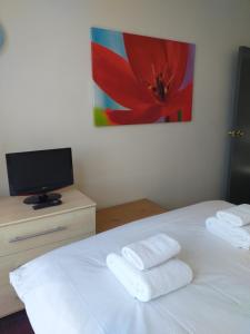 a bedroom with a white bed with towels on it at Dickie's View in Scarborough