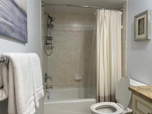 a bathroom with a tub and a toilet and a shower at An Island Getaway at Palm Tree Villas in Holmes Beach