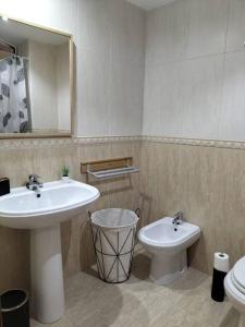 a bathroom with a sink and a toilet and a mirror at Precioso apartamento renovado in Ribeira