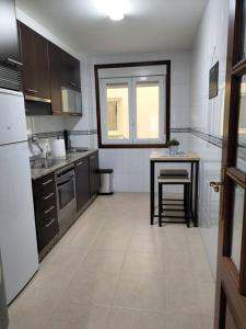 a kitchen with a table and a table and a counter at Precioso apartamento renovado in Ribeira