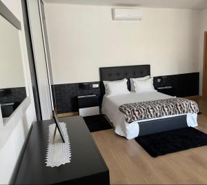 a bedroom with a bed with a black and white comforter at Casa da Tapada in Torre de Moncorvo