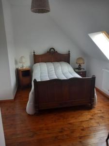 a bedroom with a large bed with a wooden floor at Gite 7pers 3 chambres in Bouvincourt-en-Vermandois
