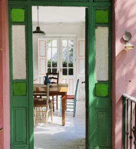 una puerta verde que conduce a un comedor con mesa en La Garibaldi 957 en Tigre