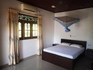 een slaapkamer met een bed en een groot raam bij Sithu Guesthouse in Bentota