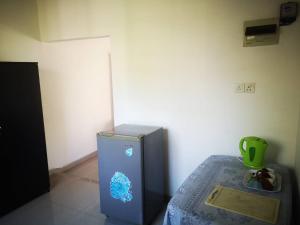 einen kleinen blauen Kühlschrank in einem Zimmer mit einem Tisch in der Unterkunft Sithu Guesthouse in Bentota