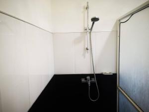 La salle de bains est pourvue d'une douche et d'une porte en verre. dans l'établissement Sithu Guesthouse, à Bentota
