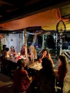 un groupe de personnes assises autour d'une table dans un restaurant dans l'établissement DespertArte espacio de Arte y Hospedaje, à Playa Blanca