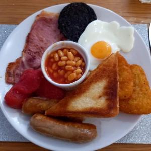 ein Frühstücksteller mit Eiern, Würstchen, Bohnen und Toast in der Unterkunft Rossall House , For Families & Couples in Blackpool