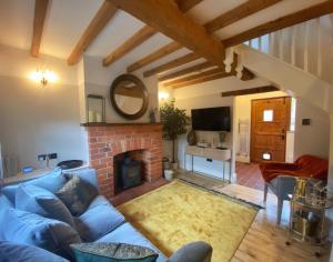 ein Wohnzimmer mit einem blauen Sofa und einem Kamin in der Unterkunft Castle View by Peake’s Retreats in Tutbury
