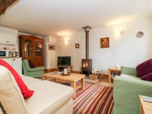 a living room with a couch and a fireplace at Apple Cottage in Crediton