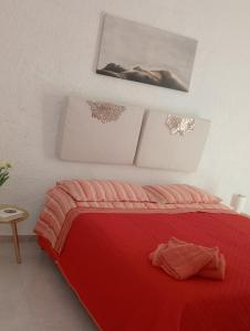 a bedroom with a red bed and a picture on the wall at Appartamento Lorena in Trapani