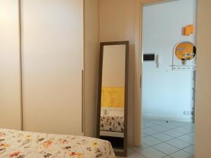 a bedroom with a mirror next to a bed at Nel blu dipinto di blu in Porto Recanati