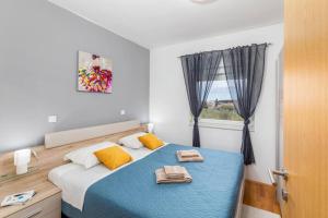 - une chambre avec un lit bleu et une fenêtre dans l'établissement Apartment LUKA, à Fažana