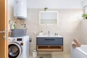 La salle de bains est pourvue d'un lavabo et d'un lave-linge. dans l'établissement Apartment LUKA, à Fažana