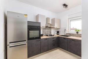 Il comprend une cuisine équipée d'un réfrigérateur en acier inoxydable et une fenêtre. dans l'établissement Apartment LUKA, à Fažana