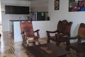een keuken met stoelen en een tafel en een aanrecht bij Hermosa casa familiar in La Tebaida