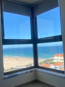 una ventana en una habitación con vistas al océano en Appartement avec vue imprenable sur l'océan, en Praia da Areia Branca