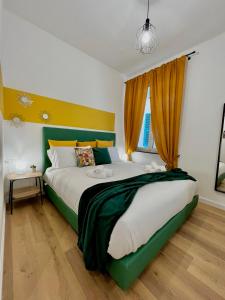 una camera con un grande letto con testiera verde di Happy Family Apartments San Luca a Genova