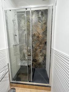 una doccia con porta in vetro in bagno di Happy Family Apartments San Luca a Genova