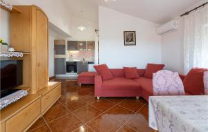 sala de estar con sofá rojo y TV en Amazing Apartment In Betiga With Wifi, en Barbariga