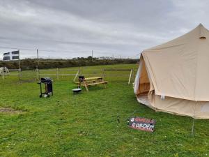 a tent and a picnic table in a field at Syds Corner bell tent in St. Just