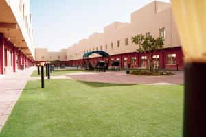 a courtyard with green grass in front of a building at فردان ريزيدانس - جدة Verdun Residence Jeddah in Obhor