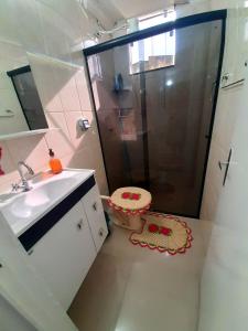 uma casa de banho com um chuveiro e um lavatório. em Apto aconchegante cuiaba em Cuiabá