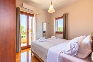 a bedroom with a bed and a large window at Gold Crest Home in Drapanias beach, Nopigia in Kissamos