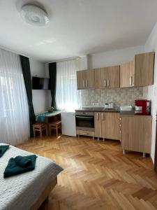 a kitchen with wooden floors and a kitchen with a counter top at Island apartman in Odorheiu Secuiesc