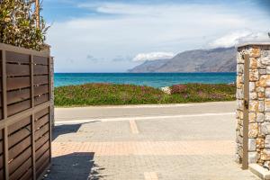 an empty road with the ocean in the background at Gold Crest Home in Drapanias beach, Nopigia in Kissamos +32 photos