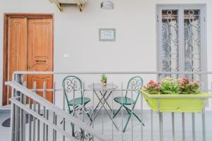 einen Balkon mit einem Tisch, Stühlen und einer Tür in der Unterkunft LE CAMERELLE in Bacoli