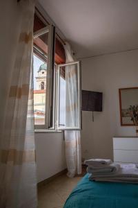 a bedroom with a bed and a large window at LE CAMERELLE in Bacoli