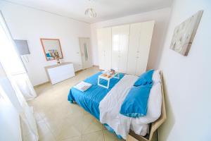 a bedroom with a blue bed and a table at LE CAMERELLE in Bacoli