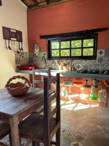 a kitchen with a wooden table in a room at Casinha do Morro - Centro Histórico in Goiás