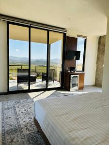 1 dormitorio con 1 cama y grandes ventanas de cristal en Villa Sophia Valle de Guadalupe, en Valle de Guadalupe