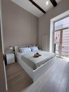 - une chambre avec un lit blanc et une grande fenêtre dans l'établissement Cosy Domy Apartments, à Naples