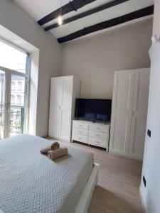 1 dormitorio blanco con 1 cama y TV en Cosy Domy Apartments en Nápoles