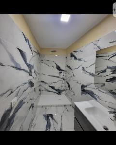 baño con paredes de mármol blanco y lavabo en Residenza San Francesco, en Zungri