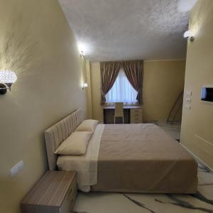 a bedroom with a bed and a desk and a window at Residenza San Francesco in Zungri