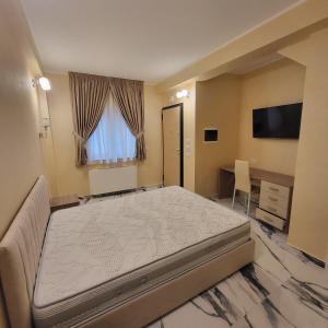 Dormitorio con cama, escritorio y TV en Residenza San Francesco, en Zungri