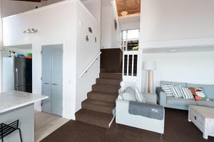 a kitchen and living room with a staircase in a house at Nelson's Lookout - Russell Holiday Home in Russell +28 photos