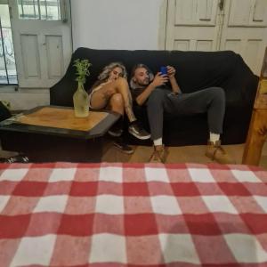 Dos mujeres sentadas en un sofá tomando una foto en Montevideo Port Hostel en Montevideo