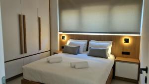 a bedroom with a large white bed with two pillows at Marigold Apartments in Chania Town
