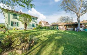 a large yard with a house and a tree at Amazing Apartment In Borghetto Di Borbera - With Wifi And 2 Bedrooms in Borghetto Di Borbera
