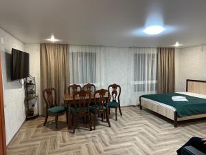 Zimmer mit einem Tisch, Stühlen und einem Bett in der Unterkunft Guest House u Feliksa in Zandrypsch