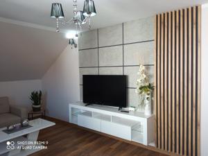  Il comprend un salon doté d'une télévision murale à écran plat. dans l'établissement Apartament Storczyk, à Augustów