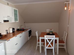 - une cuisine avec une table et des chaises dans la chambre dans l'établissement Apartament Storczyk, à Augustów