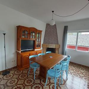 - une salle à manger avec une table, des chaises et une télévision dans l'établissement Casa sella Asturias, à Arriondas