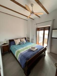 a bedroom with a large bed with a ceiling fan at Casa Rural Verde Oliva in Baños de la Encina